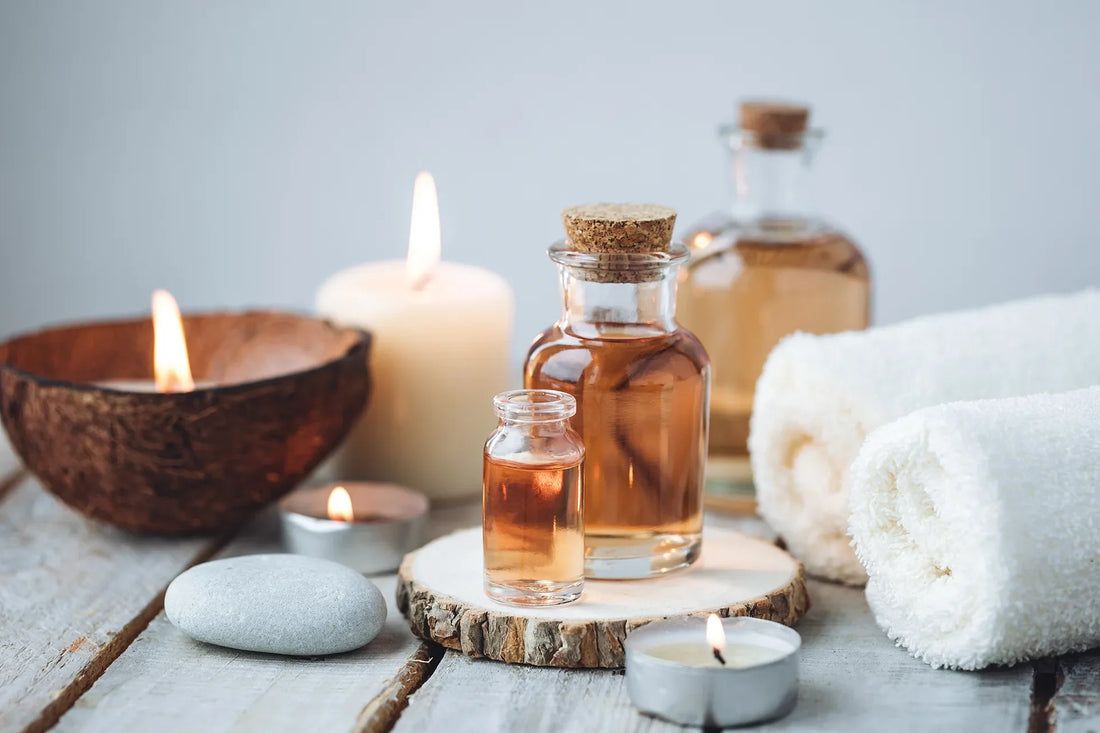 Presentation d'huile, de bougie et serviette dans un décor gris, zen.