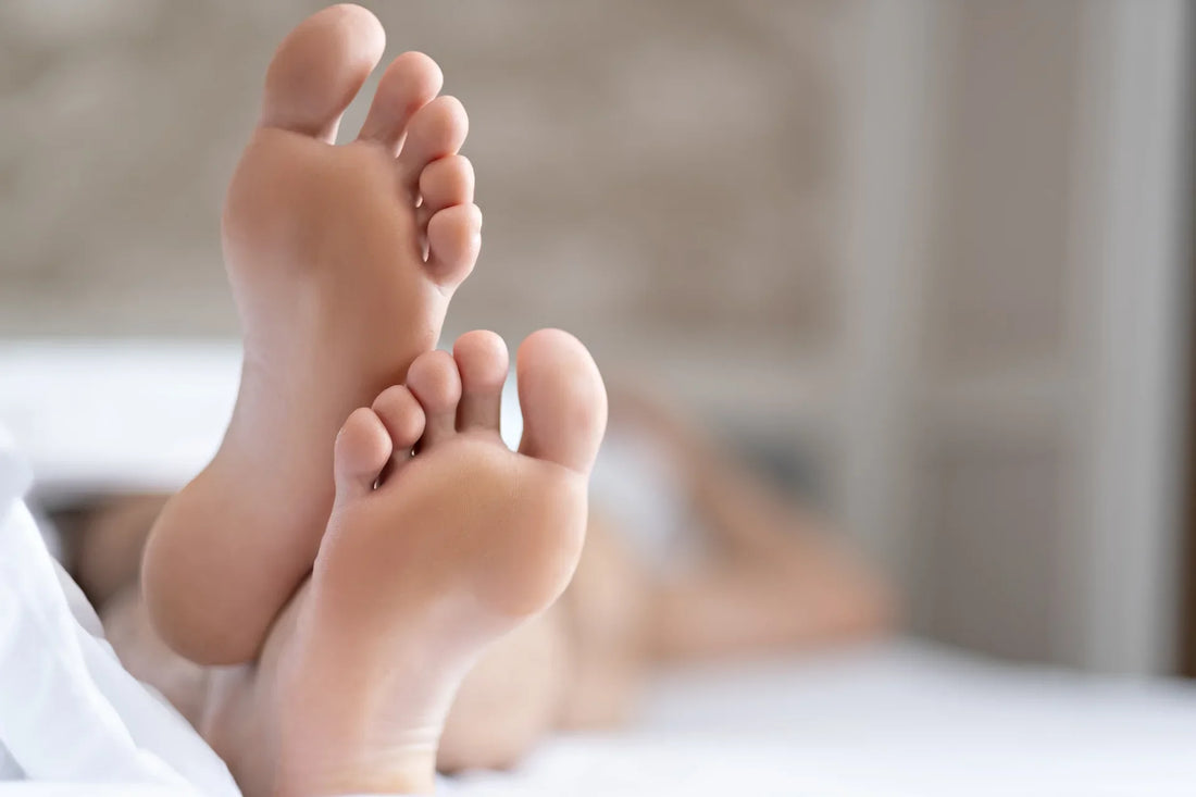 Femme allongé sur son lit prise en photo du pieds de lit. Flou de l'image autour des pieds.