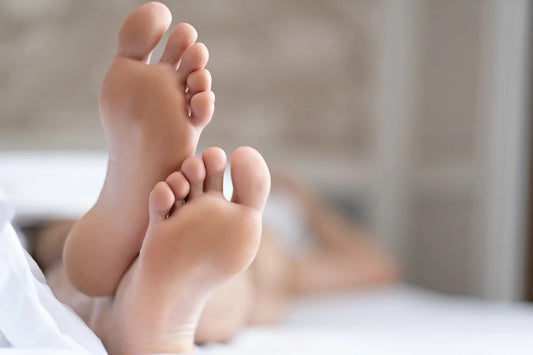 Femme allongé sur son lit prise en photo du pieds de lit. Flou de l'image autour des pieds.